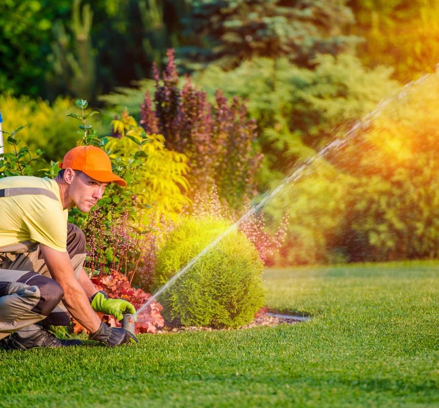 A man adjusts a sprinkler for a lawn Greenwood Lawn Care Bend Oregon